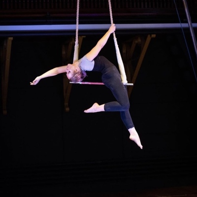 Performer from SHOW Circus Studio in Easthampton, Massachusetts, leaning back on a trapeze