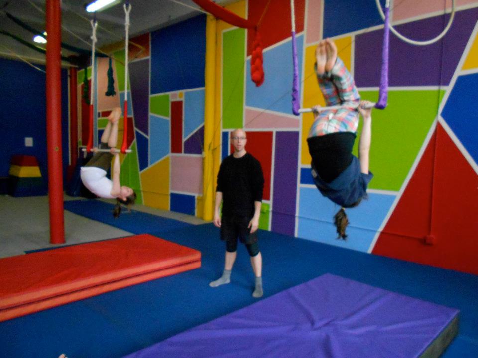 Instructor watching two inverted students on trapezes at SHOW Circus Studio in Easthampton, Massachusetts