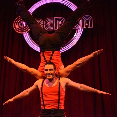 Performer from SHOW Circus Studio in Easthampton, Massachusetts, supporting another, inverted, performer shoulder-to-shoulder