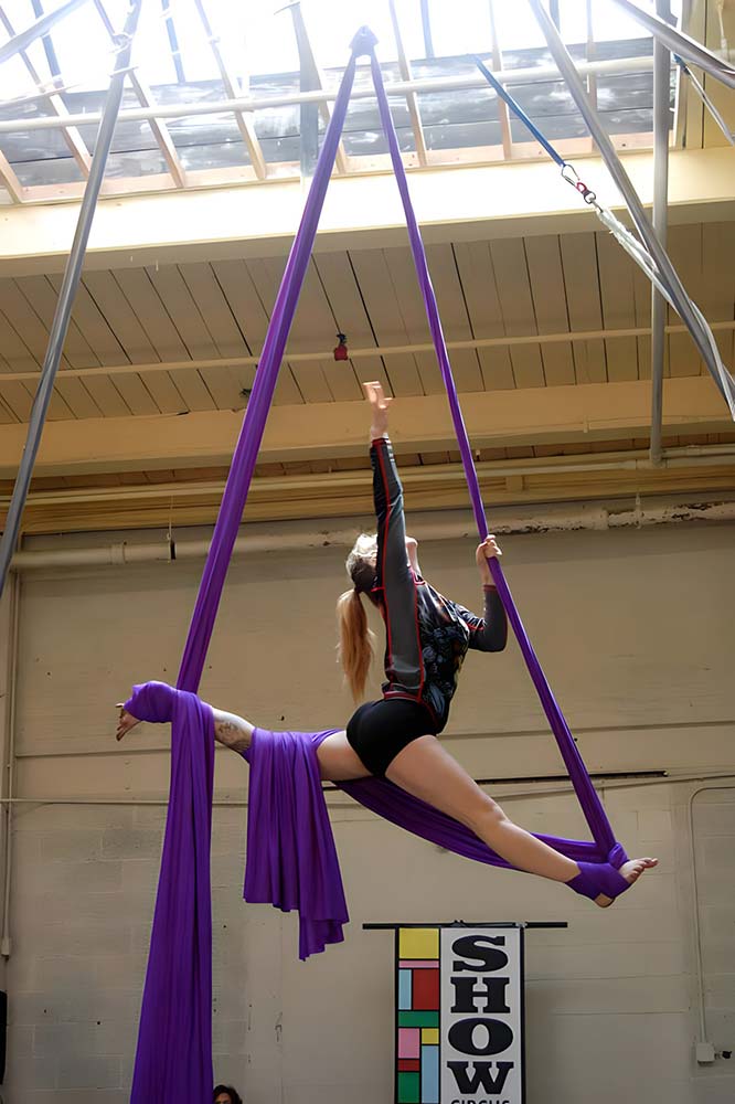 Student practicing a split on hanging fabric at SHOW Circus Studio in Easthampton, Massachusetts