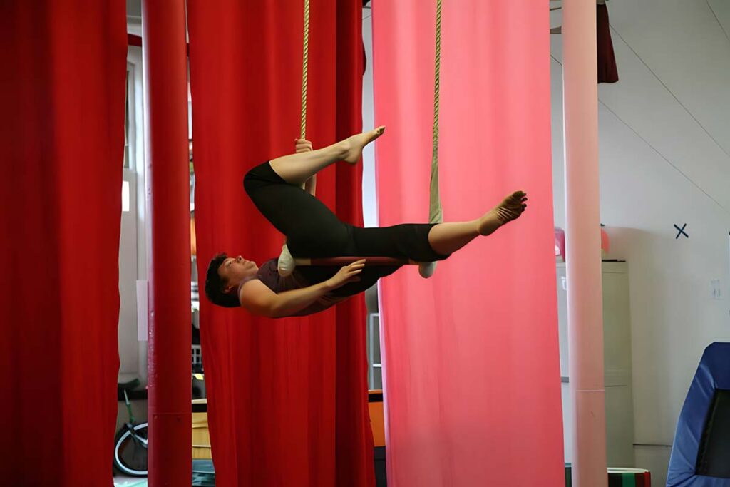 Performer lying back on a trapeze at SHOW Circus Studio in Easthampton, Massachusetts